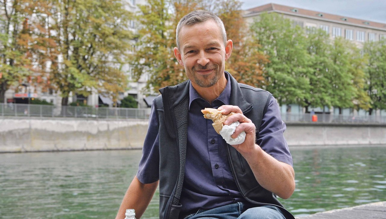 Urs Brändli beim Mittagessen an der Limmat in Zürich; zu essen gibts ein Bio-Sandwich aus dem Migros-Bio-Take-away vom Bahnhof Zürich. (Bild Tamara Wülser)