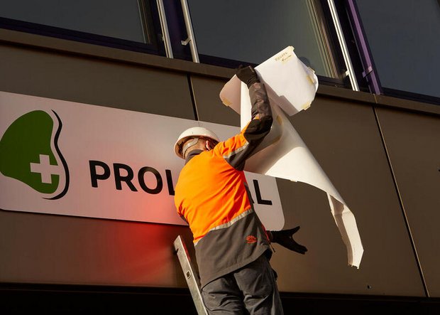 Ein Greenpeace-Aktivist überklebt das Proviande-Logo. (Bild zVg)