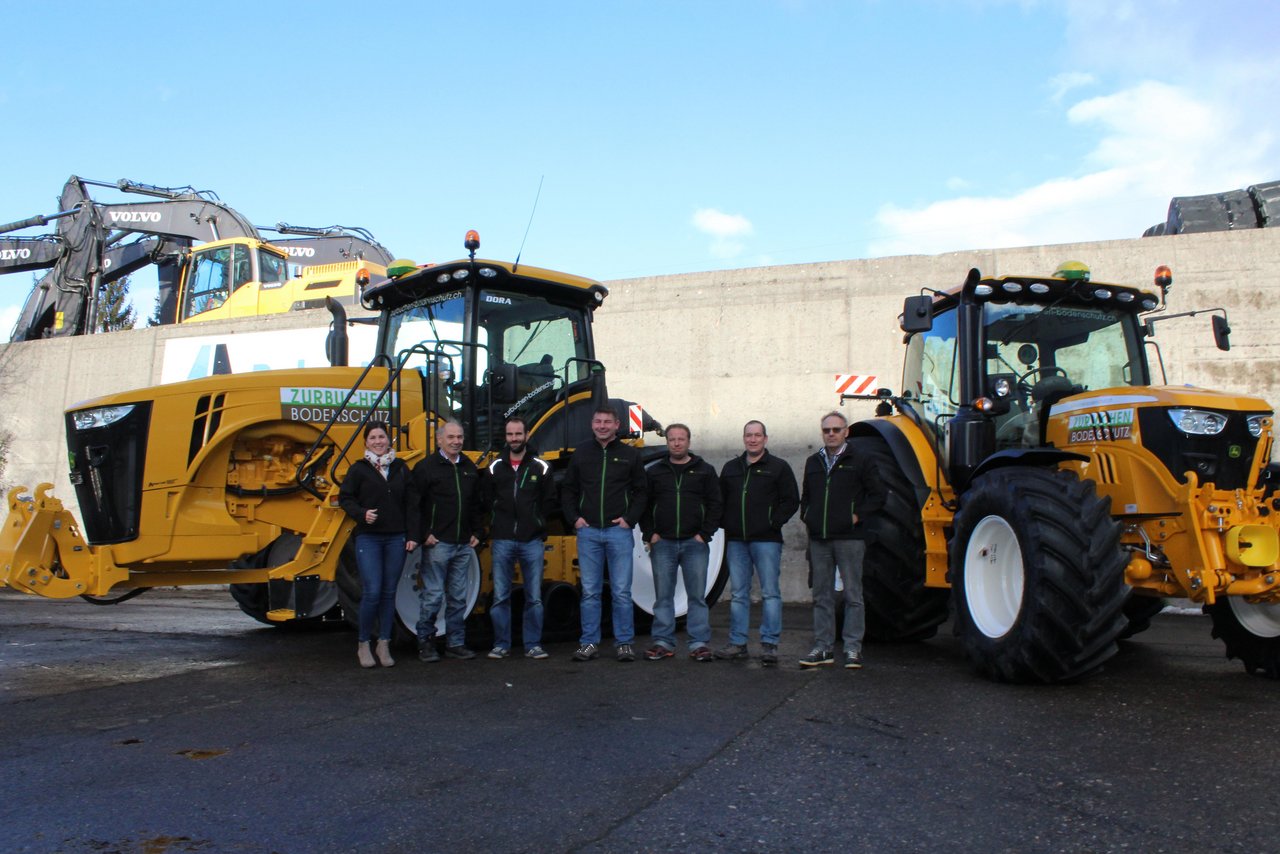 Team von Zurbuchen Bodenschutz vor dem neuen JohnDeere Raupentraktor. (Bild zVg)