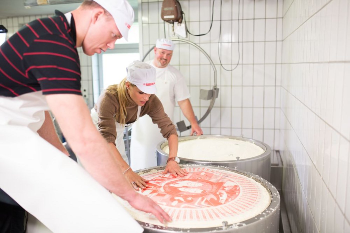 Hunziker und Sempach versehen die zwei an diesem Tag hergestellten Laibe Emmentaler AOP mit einer speziellen Etikette, welche vom Konterfei der beiden geziert wird. 