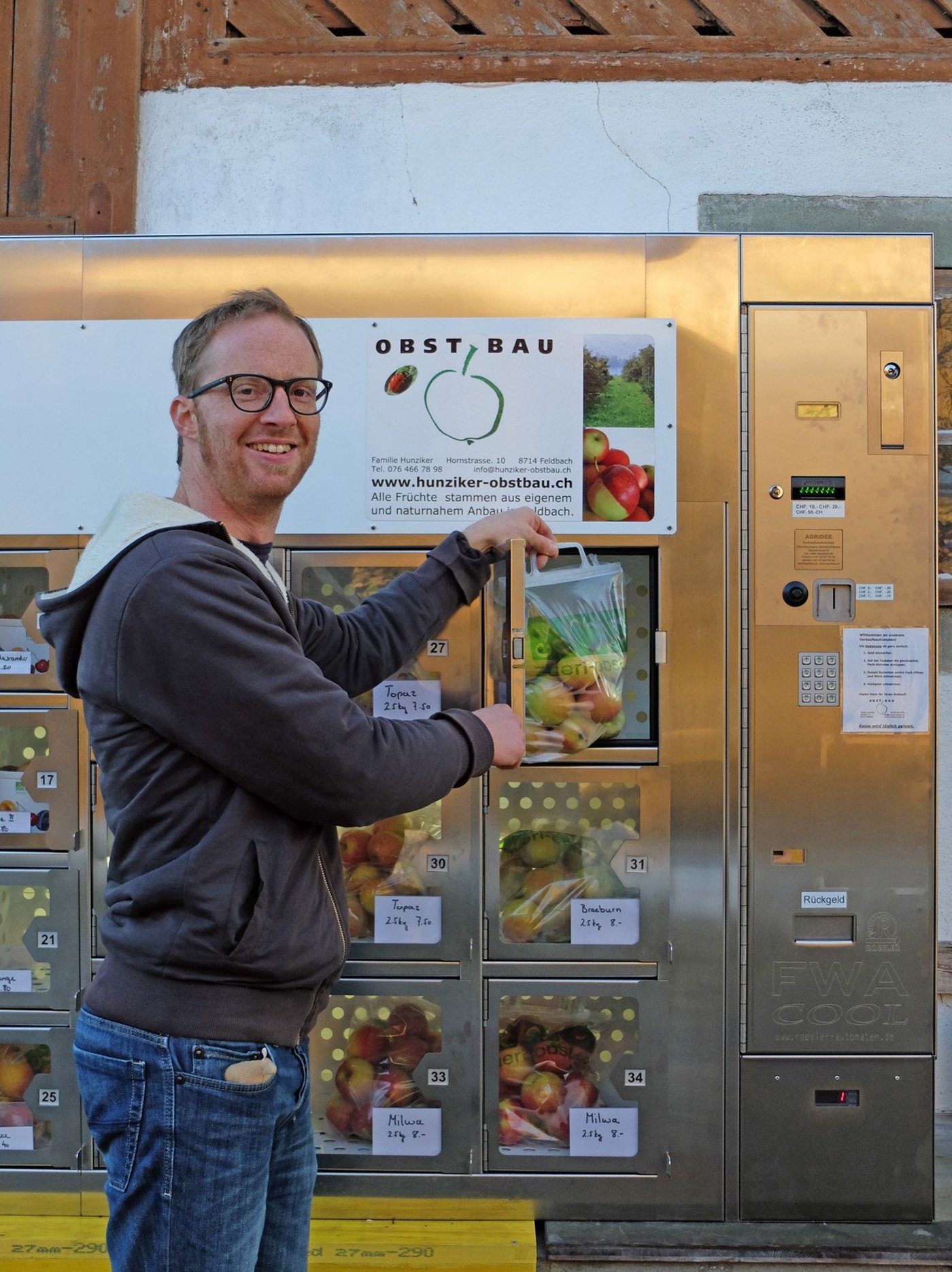 Münze einwerfen und Äpfel herausnehmen: Kaspar Hunziker vor seinem Früchte-Automaten. (Bild: zvg)