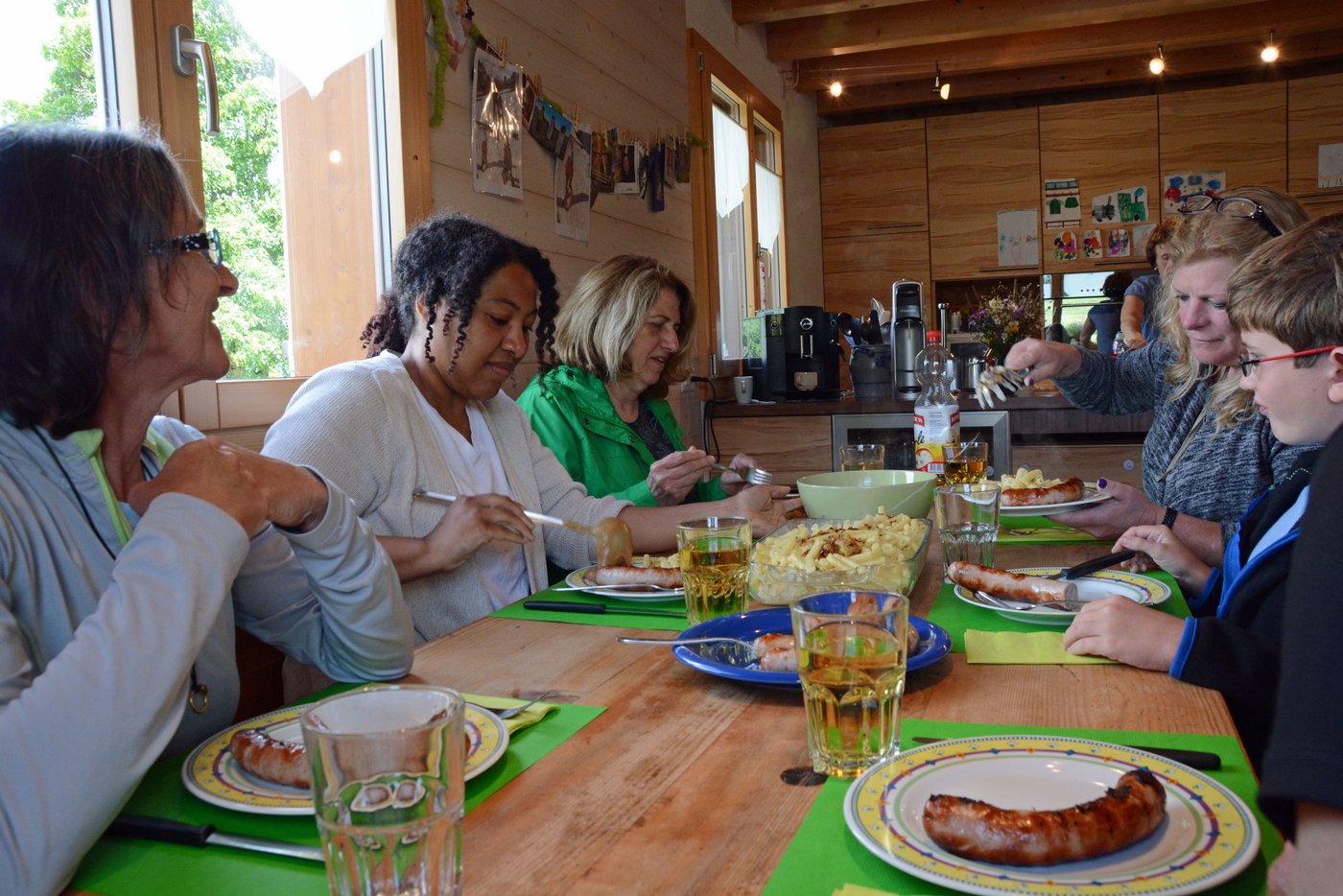 Das gemütliche Zmittag mit Kalbsbratwurst und Älplermagronen mit Apfelmus. Caroline Hostettler (links) erklärt ihren Gästen alles.