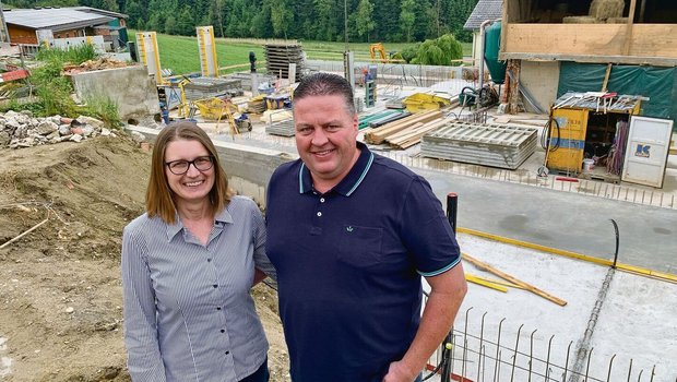 Natalie und André Frank auf der Baustelle für die neue Scheune. Hinten in der Mitte das neue Wohnhaus, links die Schweinescheune.