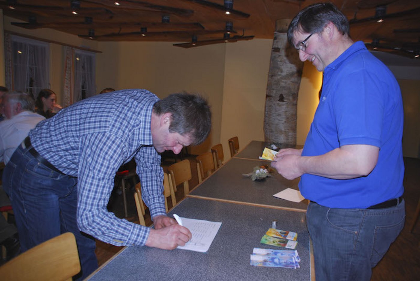 Stefan Böhni (rechts) zahlt Milchgeld  an die Produzenten der Käsereigenossenschaft Au/Fischingen im Restaurant zum Tulpenbaum in Neubrunn.