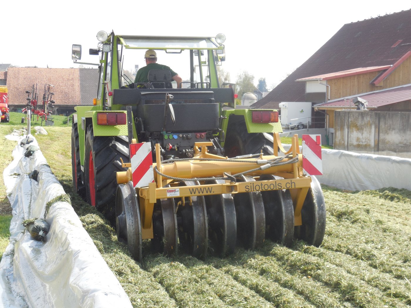Lukas Leu bei der Verfestigung im Fahrsilo mit Traktor und schwerer Walze.  