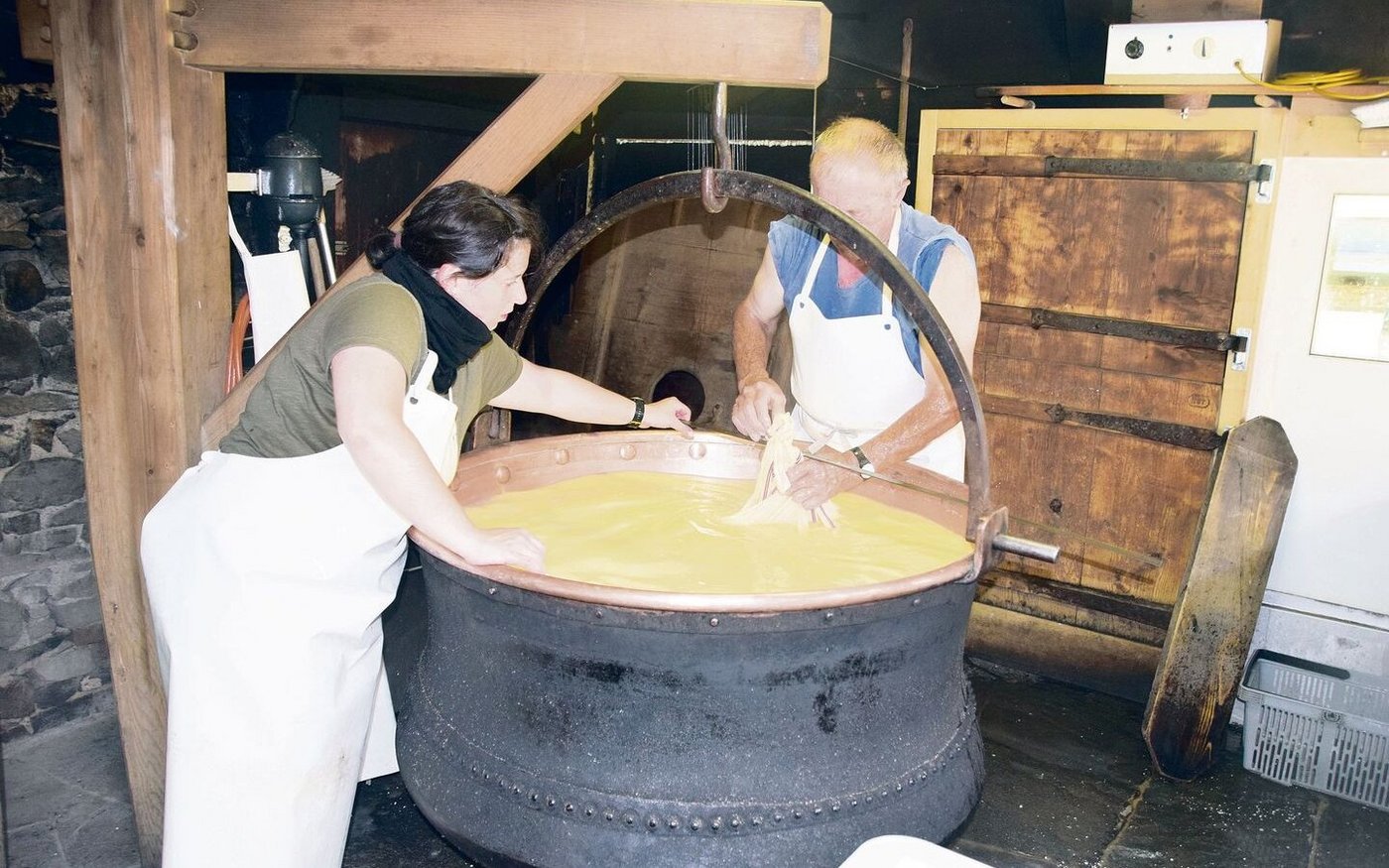 Nun wird es Zeit: Ruedi Jordi und Zusennin Regula Scheuner sind daran, den Käsebruch aus dem Kessi zu nehmen. 