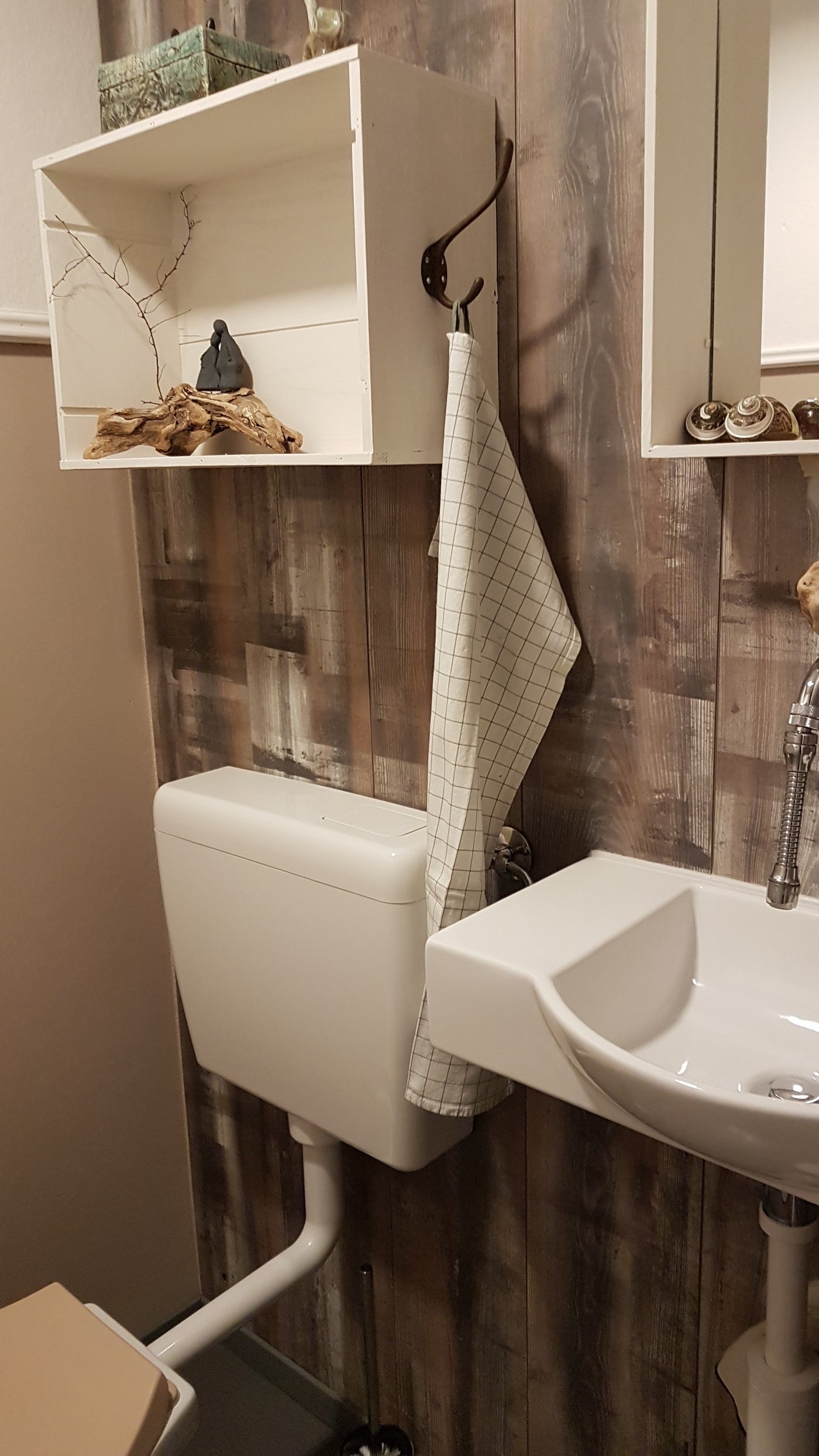 Nachher: Die alten Wandplättli wurden teilweise verputzt oder gestrichen. Eine Wand wurde mit einem Resten Bodenparkett verkleidet. Alte Weinkisten dienen, frisch gestrichen, als Ablage. (Bild Christa Felder)