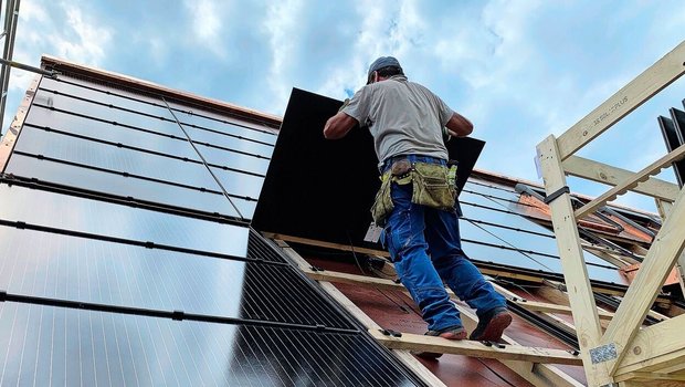 Montage von PV-Modul Montage von PV-Modulen für eine Indachanlage auf einem Neubau. Solche Systeme sind zwar teurer als Aufdachanlagen, dafür können die Ziegel eingespart werden.