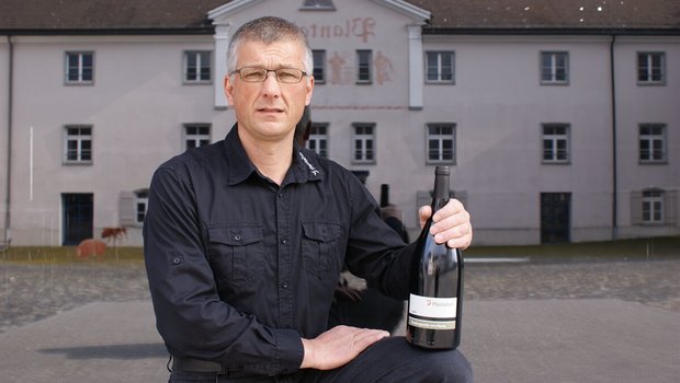 Der Rebmeister Moritz Villiger posiert mit dem Bündner Regierungswein, der künftig ebenfalls am Plantahof in Bioqualität produziert werden wird. (Bild zVg)