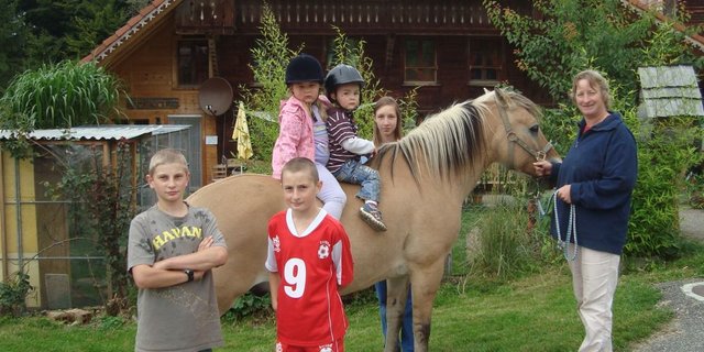 Karin Wyss mit zwei ihrer drei Söhne (vorne im Bild) sowie Kindern, die regelmässig zur ihr auf den Hof kommen. (Bild: Brigitte Meier)