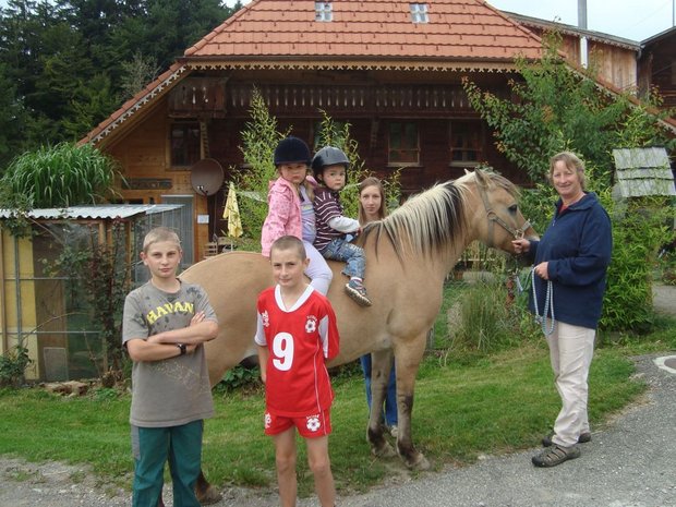 Karin Wyss mit zwei ihrer drei Söhne (vorne im Bild) sowie Kindern, die regelmässig zur ihr auf den Hof kommen. (Bild: Brigitte Meier)