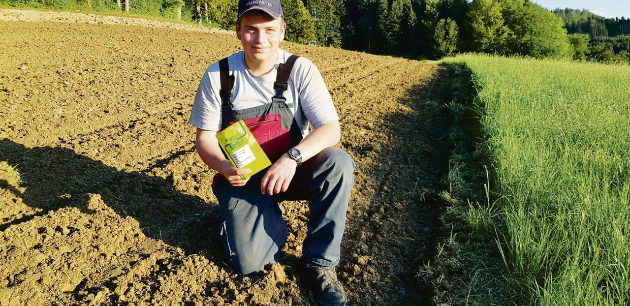 Junglandwirt Simon Jurt aus Rickenbach sät die Sonnenblumensamen am Feldrand aus. Soeben wurde das Feld geackert und der Mais wurde in den Boden gesät. Die Blumen sollen im Sommer die Spaziergänger am Wegrand erfreuen.(Bild fj)