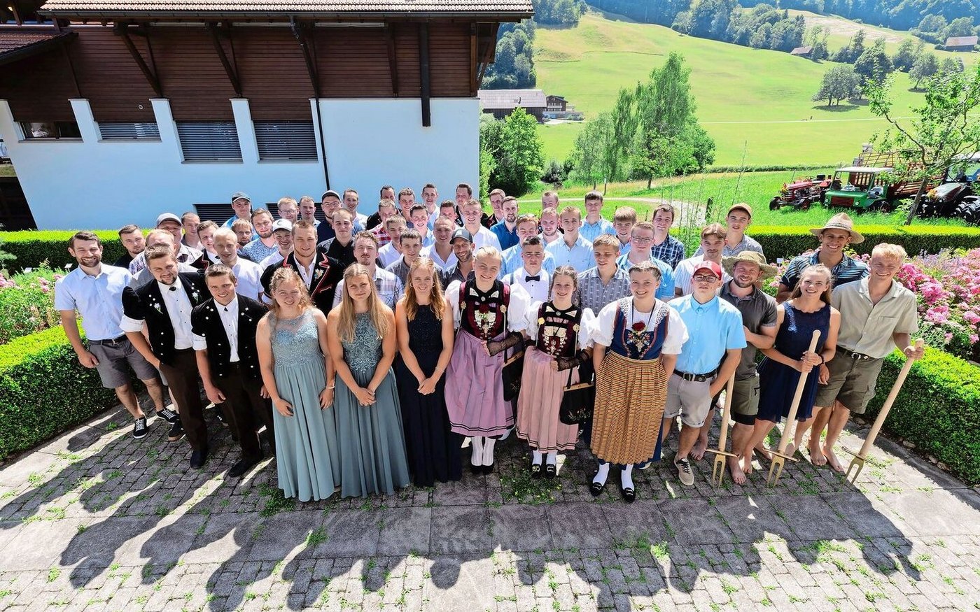 Die drei Klassen Landwirt/in EFZ auf dem Schulareal des BBZN in Schüpfheim. Die Bio-Absolventen bekamen ein goldenes Blackeneisen mit auf den Weg (rechts).