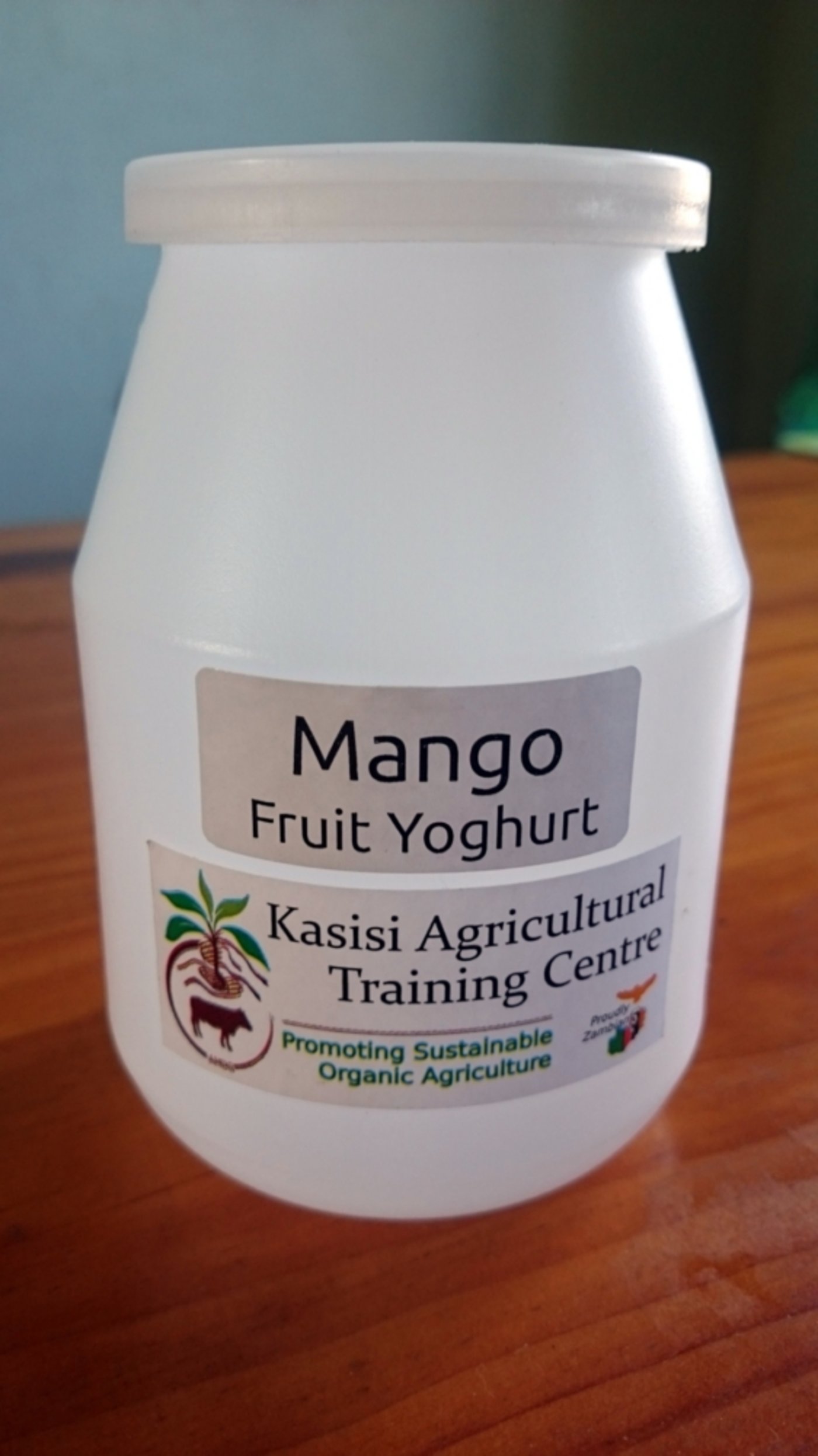 Ein leerer Joghurtbecher, nur mit Label bekleidet, steht Modell.