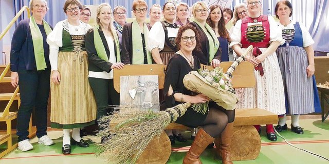 Lotti Baumann mit ihren Abschiedsgeschenken, umringt von den Bezirkspräsidentinnen und Vorstandsfrauen, hinter ihr in der Tracht die neue Präsidentin Andrea Hochuli.