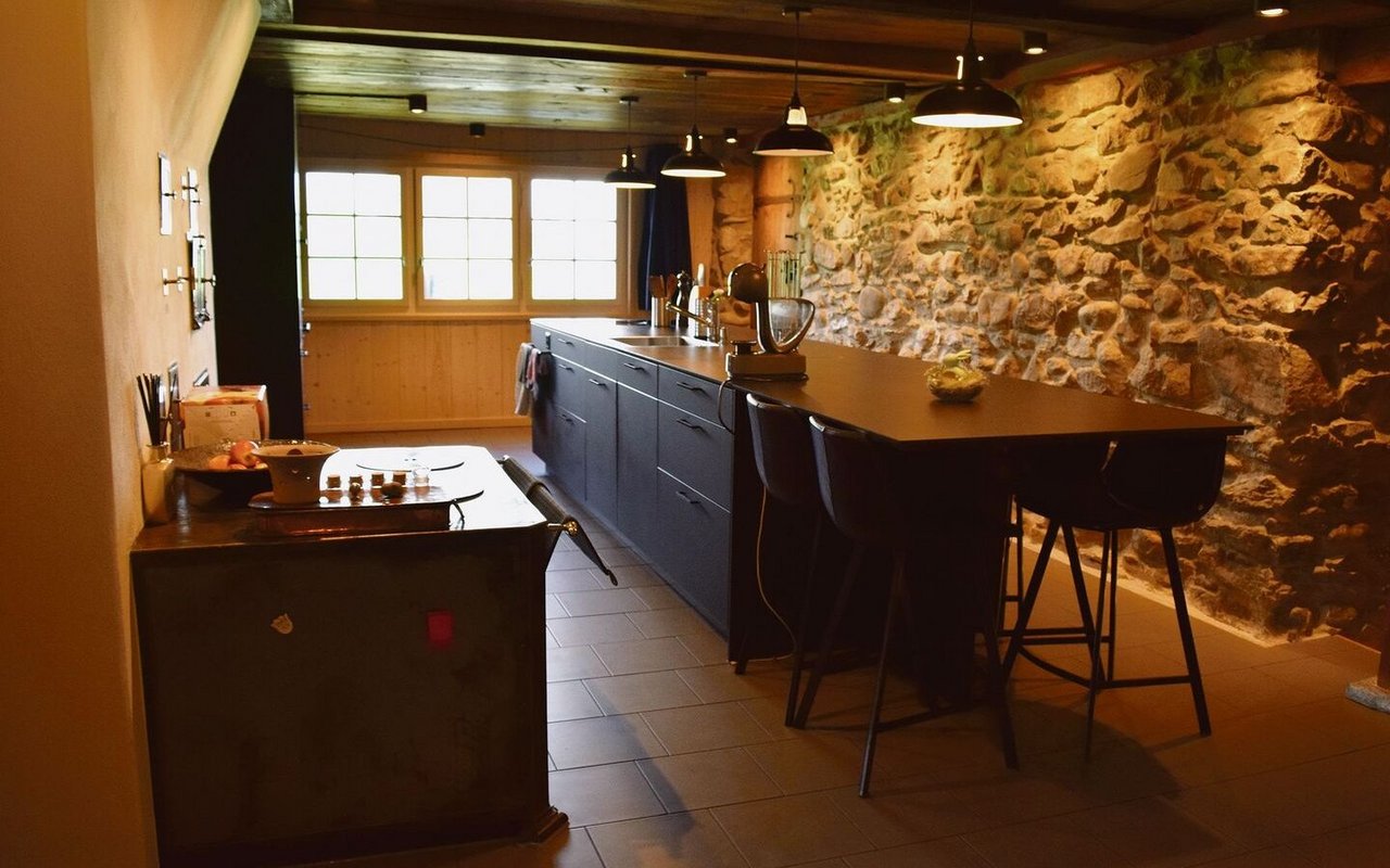 Die Küche mit der integrierten Turmmauer ist das Herzstück des Bauernhauses.