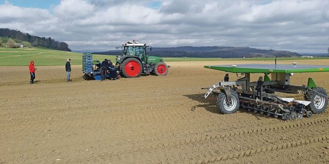 FiBL-Versuch in Rheinklingen: Im Vordergrund sät der Farmdroid und im Hintergrund setzt die Pflanzmaschine.