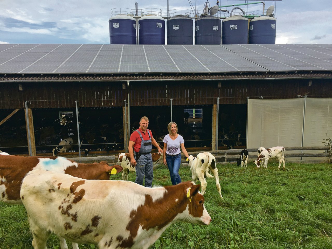 Christine und Thomas Gerber in der Kälberweide vor dem 2009 erbauten Milchviehstall mit Platz für 100 laktierende Kühe. Die 100 000er-Kühe habe er auch dem Stall zu verdanken.(Bild Armin Emmenegger)
