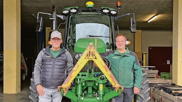 Thomas (links) und Marc Grüter stehen vor einem ihrer John Deere-Traktoren.