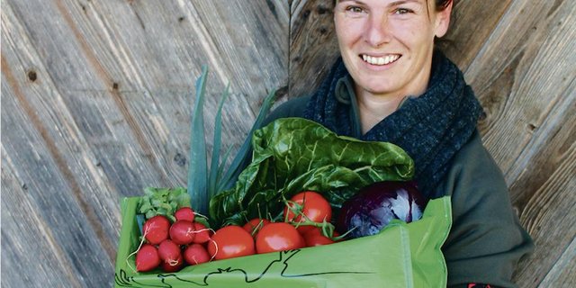 Nicole Rohrbach übergibt die  Bestellungen in grünen, wiederverwendbaren Taschen der Post. (Bild zVg)