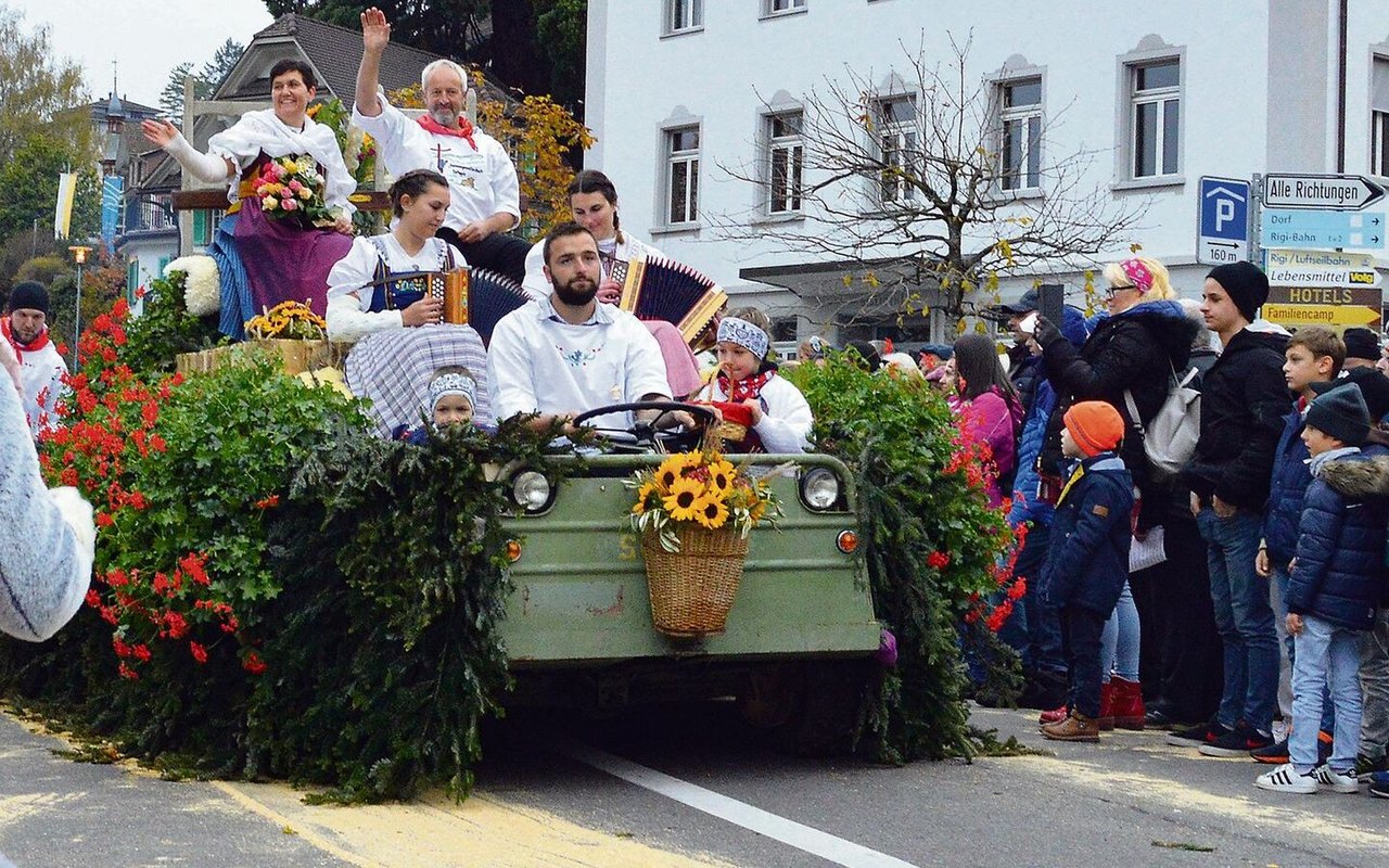 Sennenammann Albert Gössi und seine Frau Paula grüssen von einem prächtig geschmückten Umzugswagen.