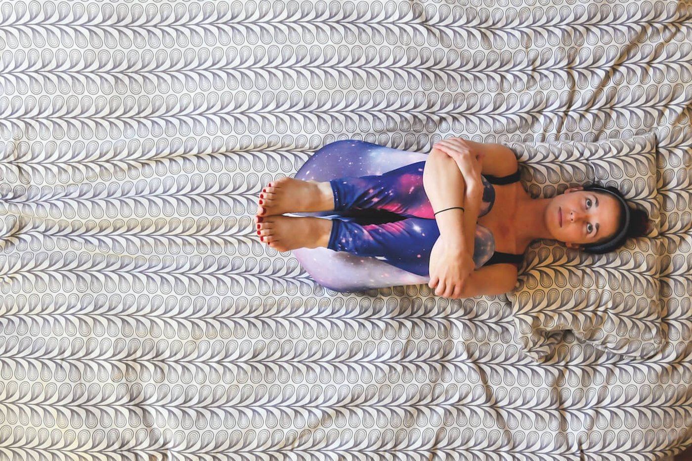 Beine anziehen, Arme um die Unterschenkel schliessen und Beine sanft an den Körper ziehen. Einige Male tief in den Bauch atmen.