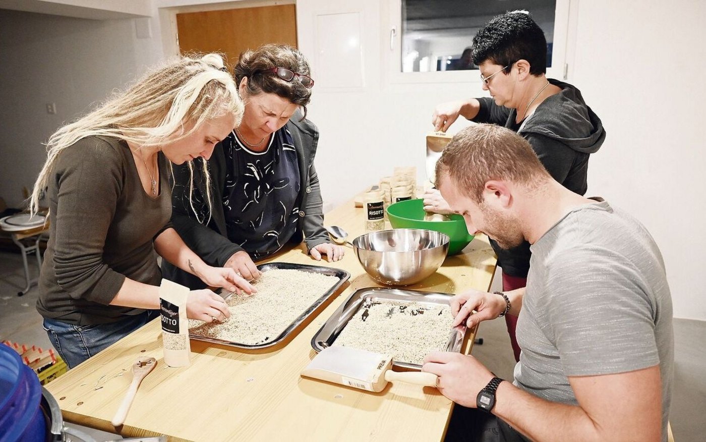 Susanne Gerber, Margrit Messerli, Christine Gerber und Timo Gerber (v. l. n. r.) erlesen und verpacken Reis.