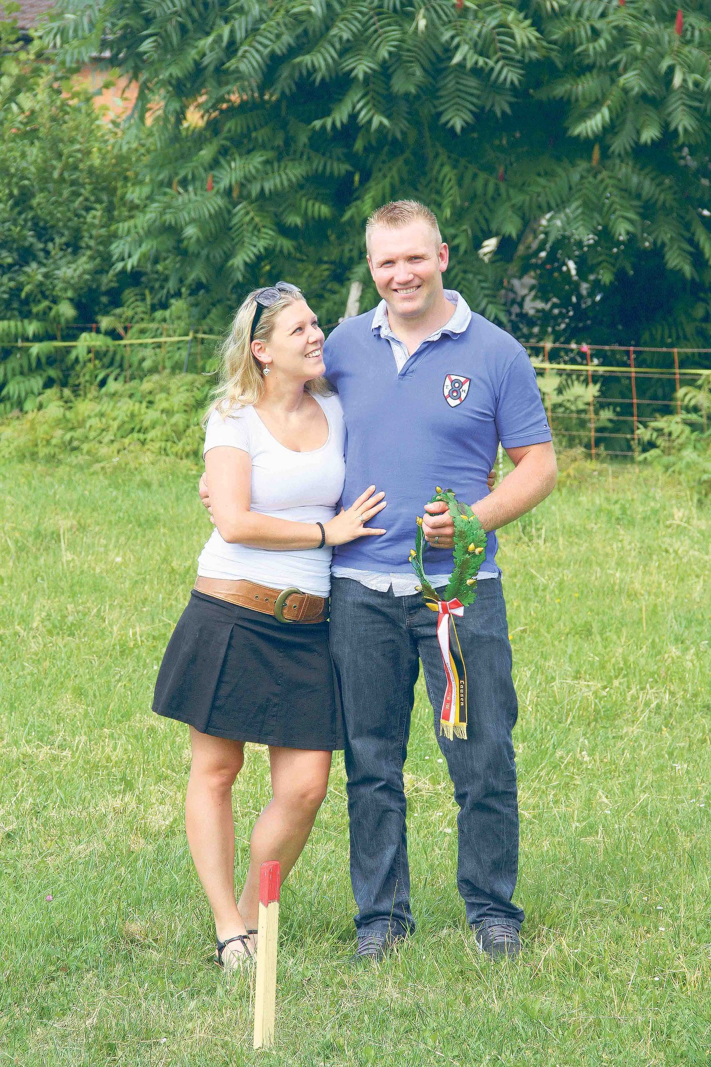 Roger Erb hält stolz seine zwei Liebsten im Arm, dort, wo bald der Spatenstich für das Eigenheim erfolgt: Seine zukünftige Ehefrau Carolle Hufschmid und das Eichenlaub seines ersten Kranzfestsieges vom Juni. 