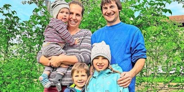 Martina und Stefan König mit ihren Kindern Nora, Lionel und Julian vor ihrer Hecke aus Beeren.  