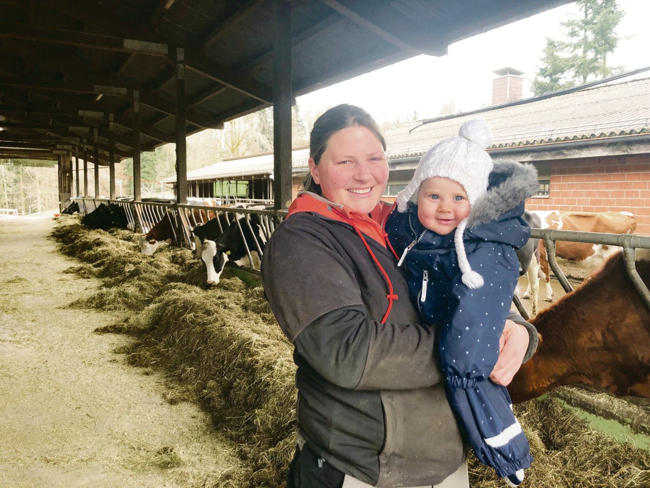 Rebecca Streit mit ihrem Strahlemädchen Aileen: Das Baby kam zwei Monate nach dem Abschluss ihrer Weiterbildung zur Meisterlandwirtin zur Welt. Im Stall stehen 45 Holstein-Kühe. Die Biomilch geht an Emmi. (Bild jw)