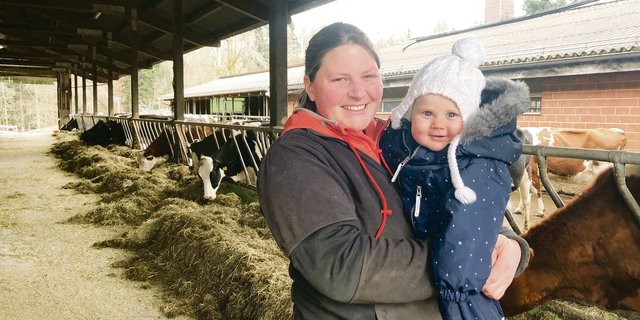 Rebecca Streit mit ihrem Strahlemädchen Aileen: Das Baby kam zwei Monate nach dem Abschluss ihrer Weiterbildung zur Meisterlandwirtin zur Welt. Im Stall stehen 45 Holstein-Kühe. Die Biomilch geht an Emmi. (Bild jw)
