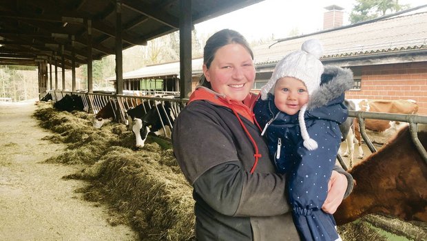 Rebecca Streit mit ihrem Strahlemädchen Aileen: Das Baby kam zwei Monate nach dem Abschluss ihrer Weiterbildung zur Meisterlandwirtin zur Welt. Im Stall stehen 45 Holstein-Kühe. Die Biomilch geht an Emmi. (Bild jw)