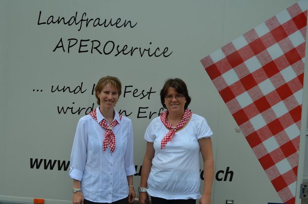 Petra Dietiker (links) und Evelyn Kuhn stehen stolz vor dem angeschriebenen Kühlwagen des Apéroservices. Sie freuen sich, dass sie sich als Unternehmerinnen und für die Wertschätzung der einheimischen Lebensmittel engagieren können. (Bild Isabelle Schwander)