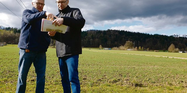 Sie wollen die zehn Hektaren grosse «Hegmatte» als Landwirtschaftsland erhalten: Hans Lüthy (l.), dem ein Drittel der Fläche gehört, und Andres Wälty vor dem umstrittenen Gebiet.  (Bild Ruth Aerni)