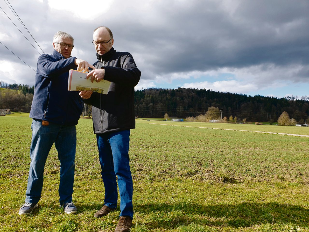 Sie wollen die zehn Hektaren grosse «Hegmatte» als Landwirtschaftsland erhalten: Hans Lüthy (l.), dem ein Drittel der Fläche gehört, und Andres Wälty vor dem umstrittenen Gebiet. (Bild Ruth Aerni)