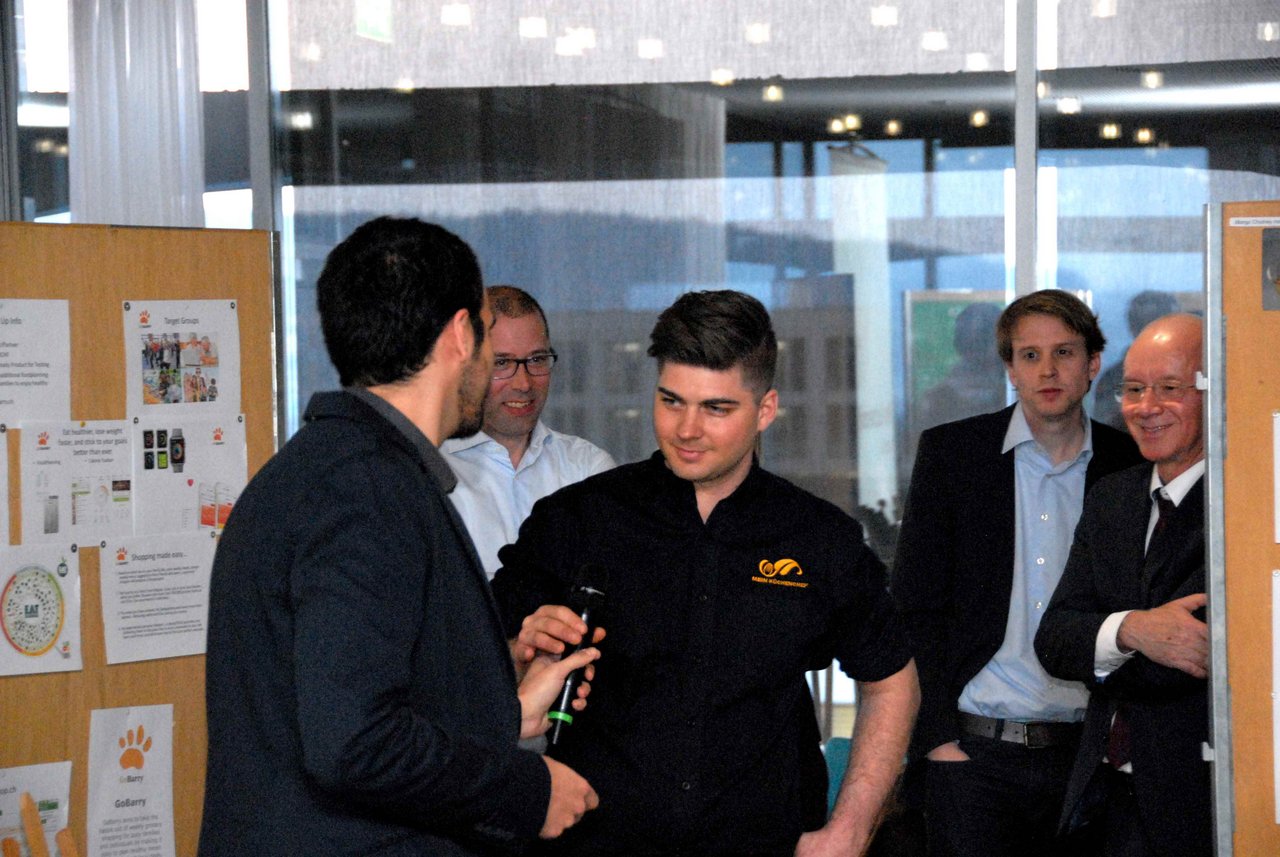 Mirko Buri (Mitte) übernimmt das Mikrofon um seine Idee zu präsentieren. Im Hintergrund: BLW-Direktor Bernard Lehmann (Bild hja)