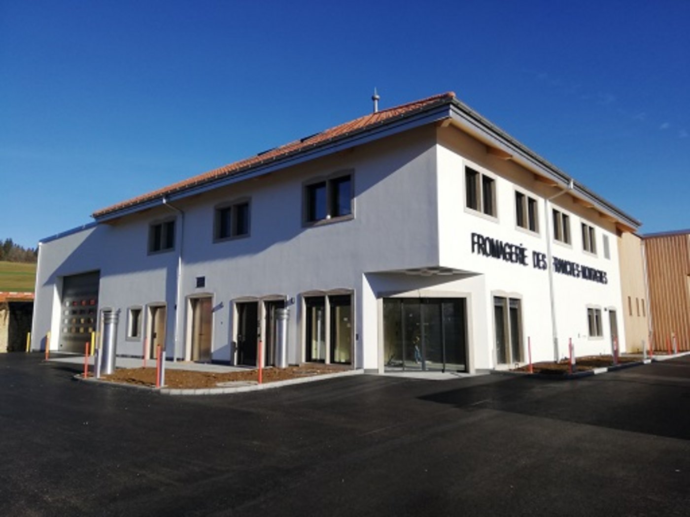 Die neue Käserei in Le Noirmont JU ist ein moderner Neubau mit Robotern im Keller und Solarplatten auf dem Dach. (Bild Fromagerie des Franches-Montagnes)