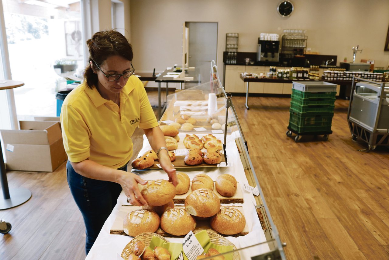 Brigitta Krummenacher räumt gerade das frisch gebackene Brot in die Theke ein. Diese steht in ihrem Partyraum, der provisorisch zum Hofladen umfunktioniert wurde, damit mehr Leute unter Berücksichtigung der Abstandsregeln einkaufen können.(Bild zVg)