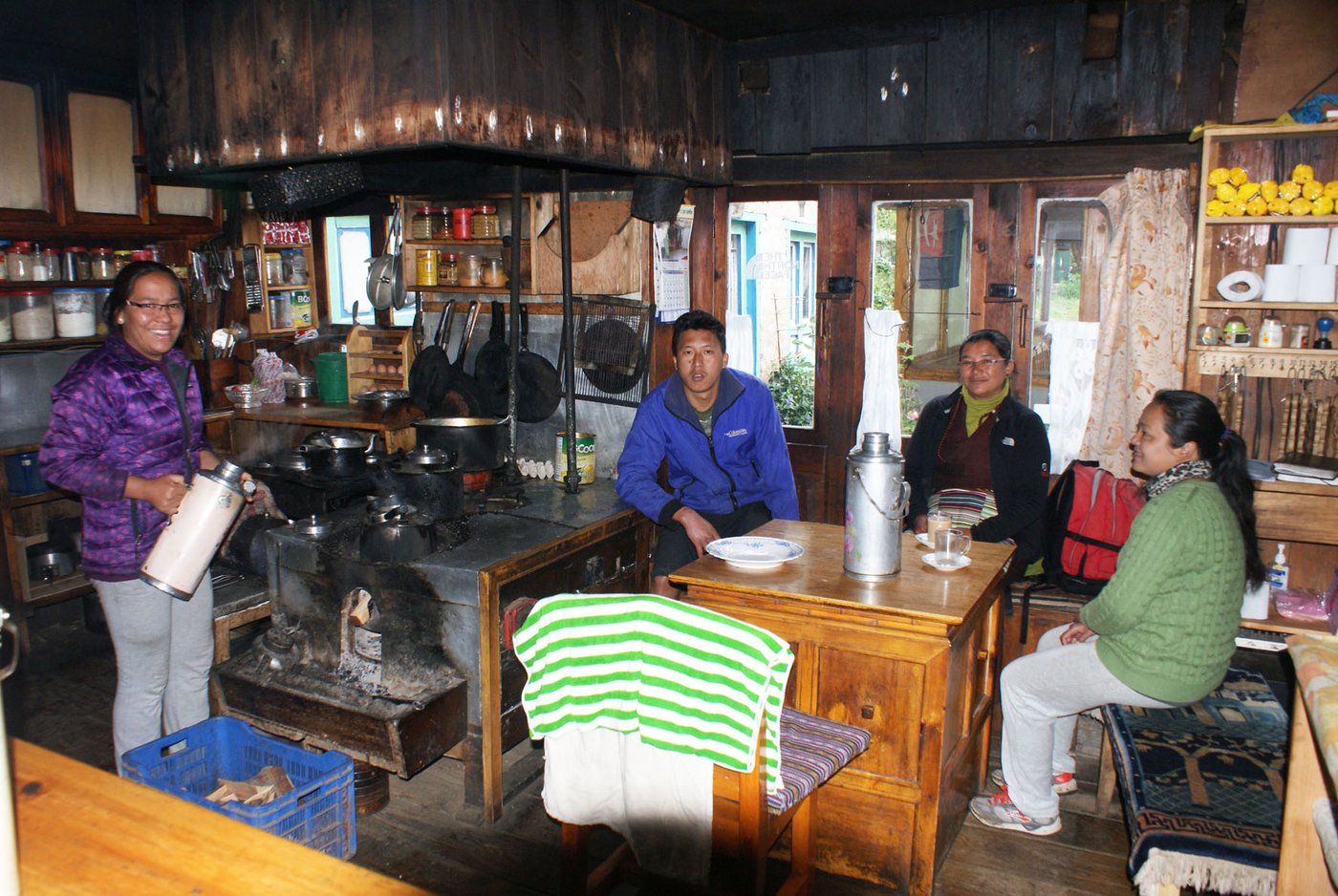 Landwirtin und Lodgekeeperin Ngimale Sherpa mit ihrem Mann Pempa Dorsi und zwei ihrer Gäste beim Servieren von Tee (v.l). 