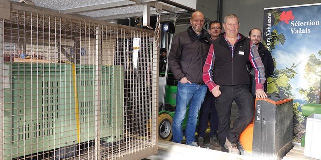 Posieren mit der Heisswasserbehandlungsmaschine: (v.l.) Pierre-André Roduit, Chef des Weinbauamts, Thierry Castellazzi, Bundesamt für Landwirtschaft, Paul-Maurice Burrin, Präsident der «Société des pépinéristes viticulteurs», Laurent Maret, Chef des Amts für Strukturverbesserungen. (Bild zVg)