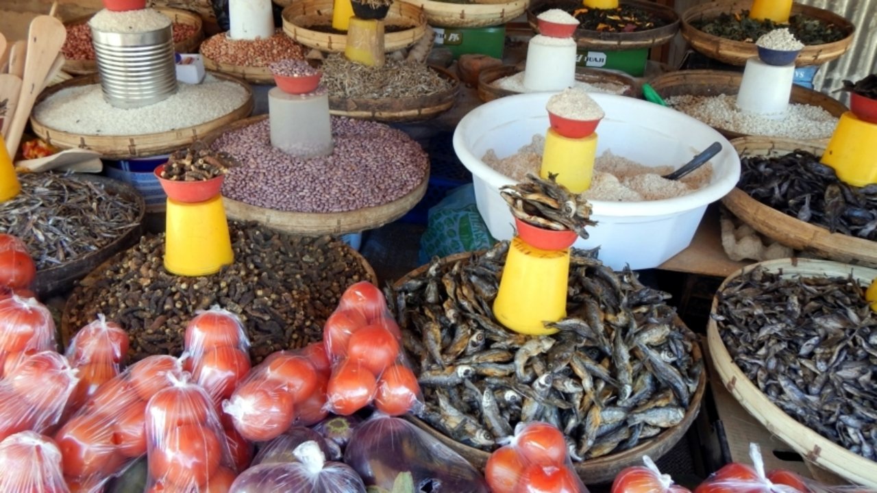 Auslage auf einem Lebensmittelmarkt in Lusaka. Erste Reihe hinter den Tomaten, von links nach rechts: „Kapenta“ (kleine, getrocknete Fische) , „Finkubala“ (Mopane-Raupen), „Mintesa“ (kleine, getrocknete Fische), „Mulonge“ (kleine, getrocknete Fische). (Bild Cornelius Köhler)