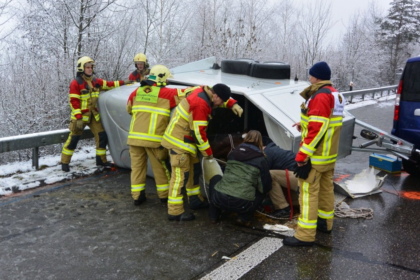 Die Berufsfeuerwehr trennt mit Spezialwerkzeug das Dach des Anhängers auf, um das Pferd zu bergen. Eine Tierärztin kümmert sich um das Pferd. (Bild: Berufsfeuerwehr Bern)