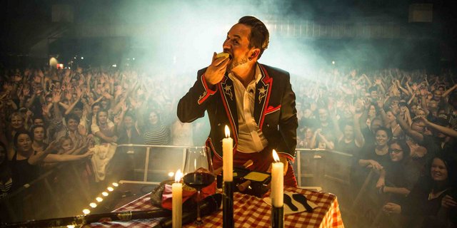 Raclette kann man auch auf der Bühne zubereiten und essen: Trauffer macht es vor. (Bild Raclette Suisse)