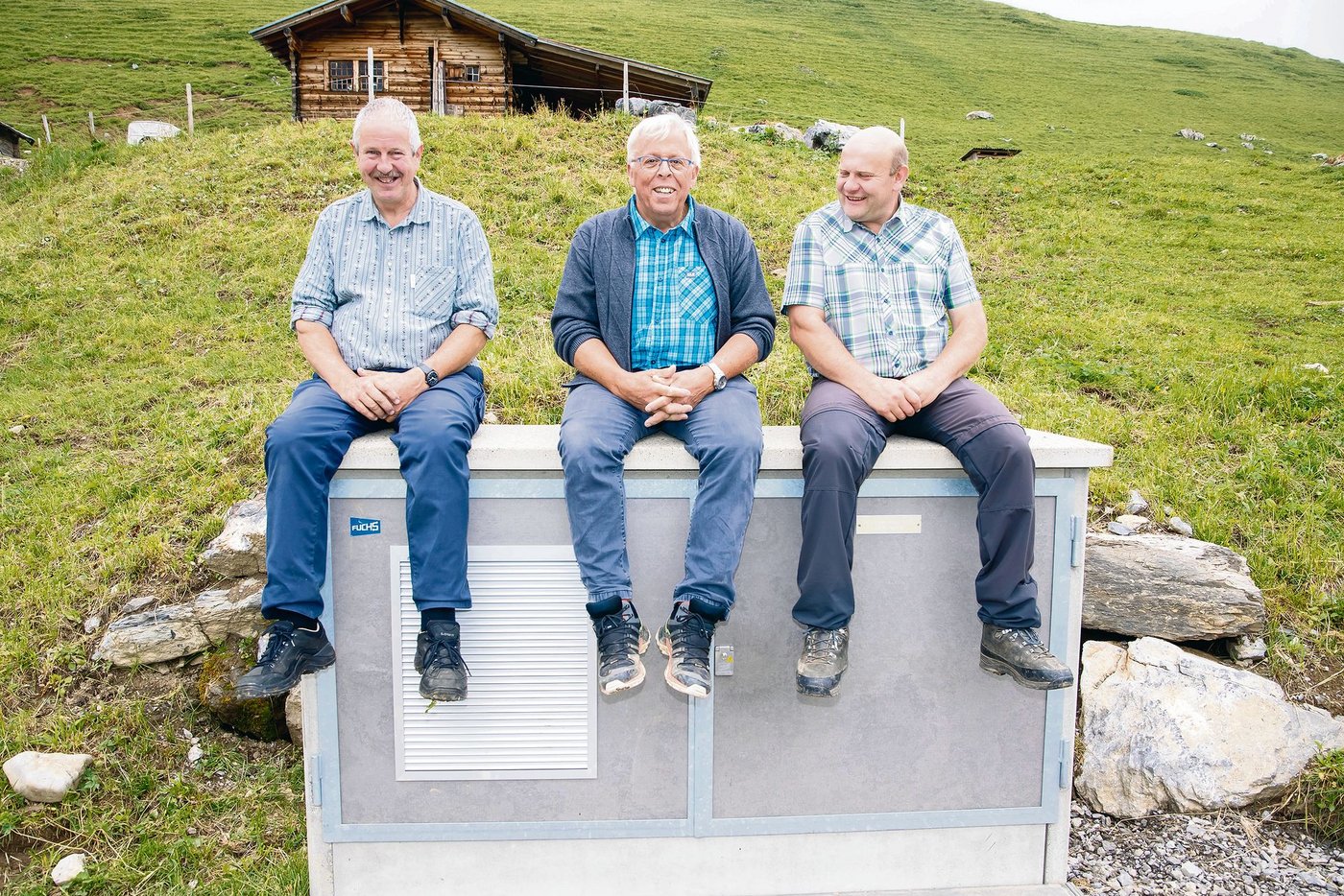 Hans Rösti, Franz Rubin und Ernst Wandfluh (v. l. n. r.) sitzen auf dem letzten Verteilerkasten im Ueschinental auf 2000 Meter über Meer.(Bild Verein Alpwirtschaft Bern)