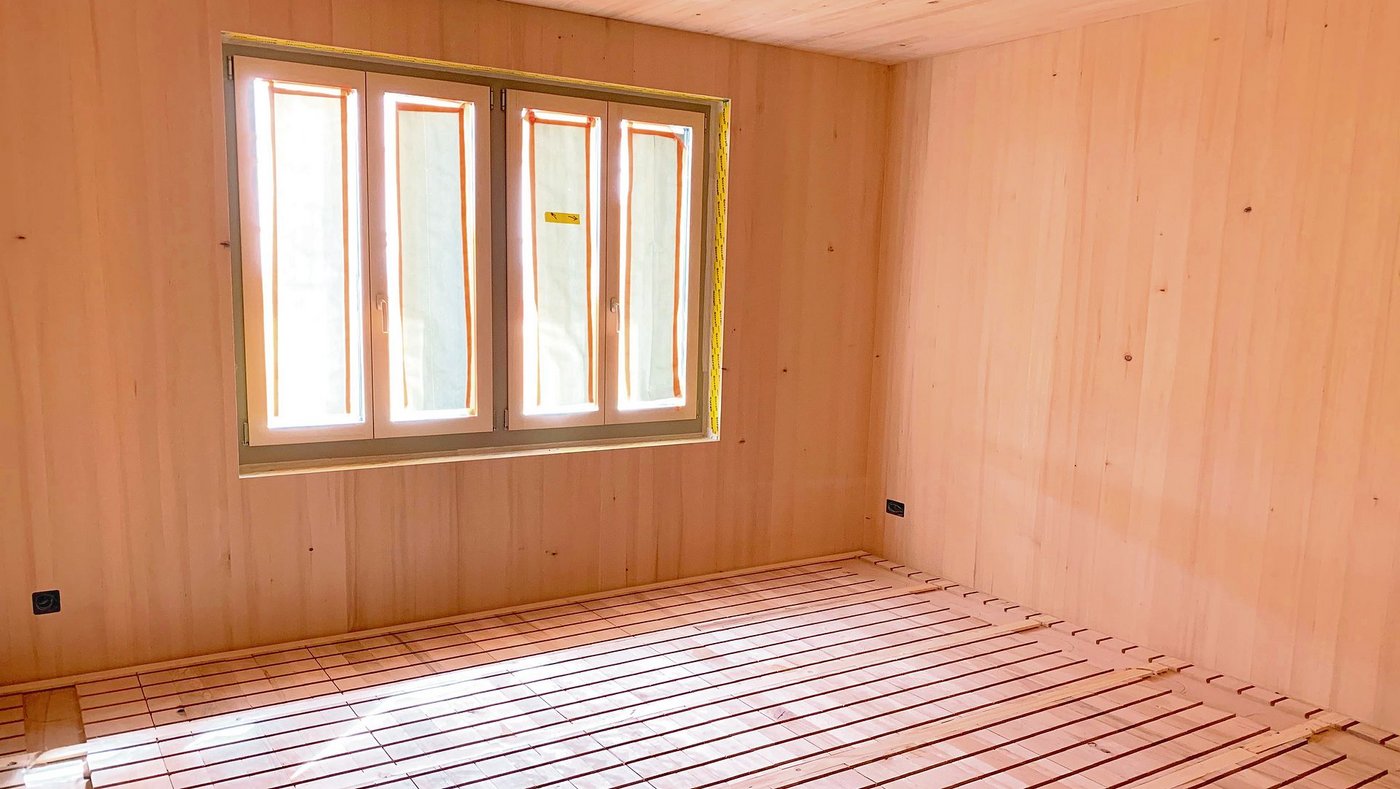 Auch innen viel Holz. Am Boden sind die Lamellen für die Bodenheizung aus eigenem Buchenholz ersichtlich. 