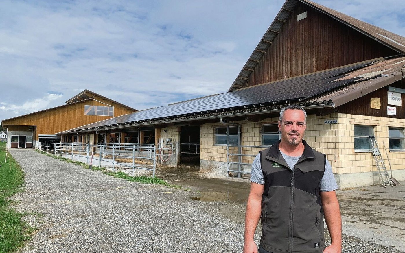 Stefan Troxler vor der 2013 erstellten Solaranlage auf dem Scheunendach. Diese wurde 2021 auf eine Leistung von 130 kWp erweitert. Der meiste Solarstrom muss ins Netz abgegeben werden.  