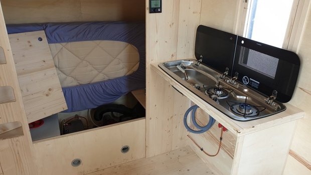 Kajütenbett und Kochecke. Die Hütte enthält Elemente aus dem Camping-Bereich. (Bild lid)