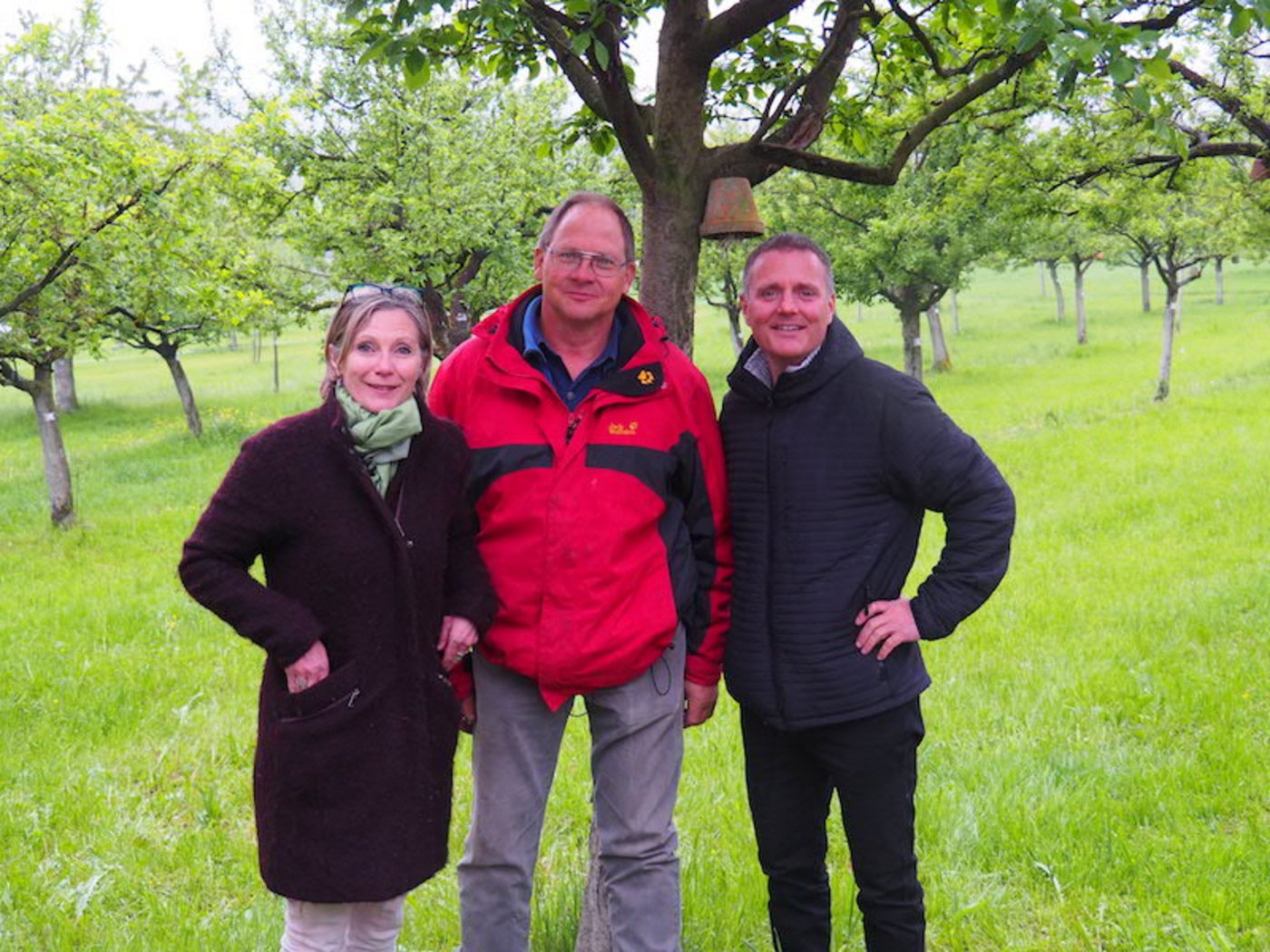 Gastgeber Jakob Kaufmann in seinem Hochstammobstgarten, umringt von Hochstamm Suisse Co-Präsidentin Maya Graf und Geschäftsführer Pierre Coulin. (Bild zVg)