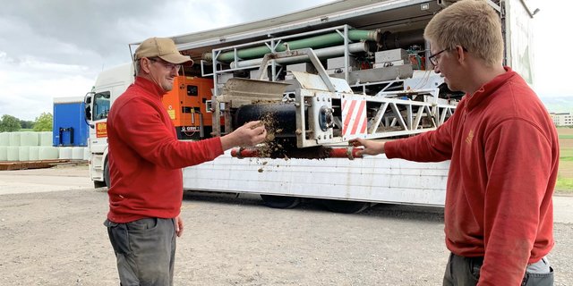 Franz Müller (l.) und Maschinenführer Marc Rogenmoser beim Förderband für den Festmist. Auf dem Lkw sind fünf Gülleseparatoren in Serie montiert. (Bild js)