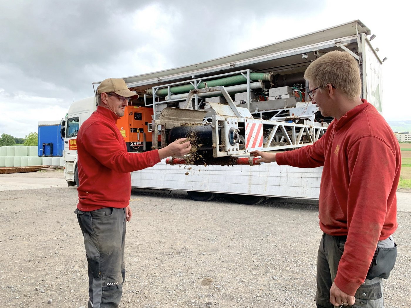 Franz Müller (l.) und Maschinenführer Marc Rogenmoser beim Förderband für den Festmist. Auf dem Lkw sind fünf Gülleseparatoren in Serie montiert. (Bild js)